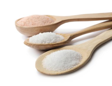 Beyaz kaşıklarda izole edilmiş farklı doğal tuz türleri.