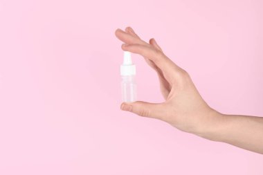 Pembe arka planda tıbbi damlaları olan bir kadın, yakın plan.