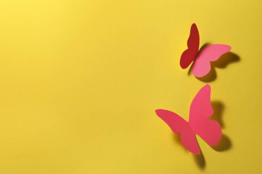 Sarı arka planda parlak pembe kağıt kelebekler