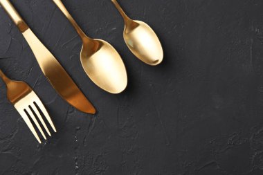 Siyah masaya kurulmuş güzel çatal bıçak takımı, düz yatıyordu. Metin için boşluk