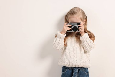 Moda konsepti. Beyaz arka planda klasik kamerası olan şık bir kız.