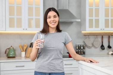 Mutfakta tatlı su bardağı ile Kadın