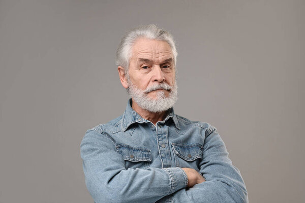 Senior man with mustache on grey background