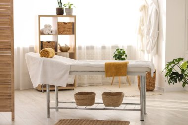 Spa merkezinde temiz havluları olan rahat masaj masası.