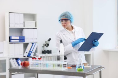 Kalite kontrolü. Gıda müfettişi ürünlerin güvenliğini laboratuvarda kontrol ediyor.