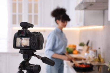 Mutfakta video kaydederken yemek blogcusu yemek pişiriyor, kameraya odaklan