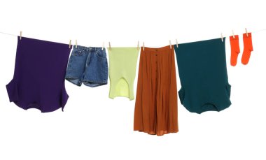 Different clothes drying on laundry line against white background