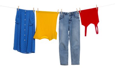 Different clothes drying on laundry line against white background