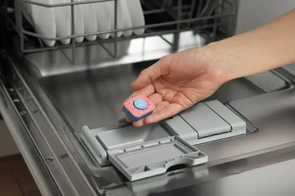 Frau Steckt Waschmittel Tablette Offene Spülmaschine Nahaufnahme lizenzfreie Stockbilder