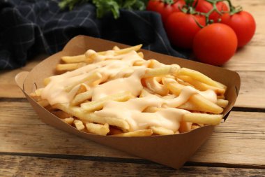 Tahta masada peynir soslu leziz patates kızartması, yakın plan.