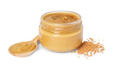 Kavanozda taze hardal sosu, beyaz üzerine izole edilmiş kaşık ve kuru tohumlar.