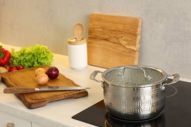 Yemek pişiriyorum. Mutfaktaki tezgahın üstünde taze sebze ve çömlek.