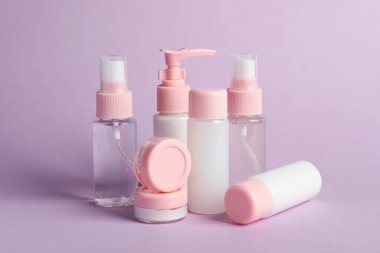 Mor arka planda kozmetik seyahat. Banyo aksesuarları