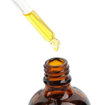 Pipetten şişeye damlayan tentür beyaza izole edilmiş.