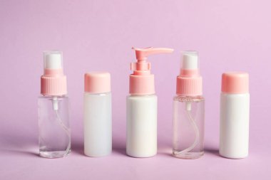 Mor arka planda kozmetik seyahat. Banyo aksesuarları