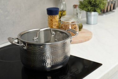 Yemek pişiriyorum. Mutfakta tencerenin üstünde.