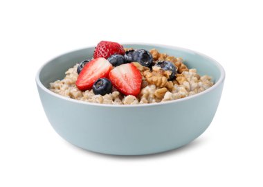 Lezzetli yulaf ezmesi, çilek, yaban mersini ve ceviz kabın içinde, beyaz üzerine izole edilmiş.