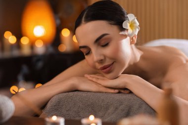 Spa terapisi. Salondaki masaj masasında uzanmış güzel genç bir kadın.