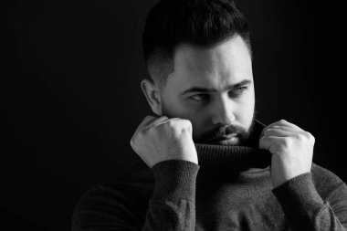 Karanlık arka planda sakallı yakışıklı bir adamın portresi, mesaj için yer var. Siyah ve beyaz etkisi