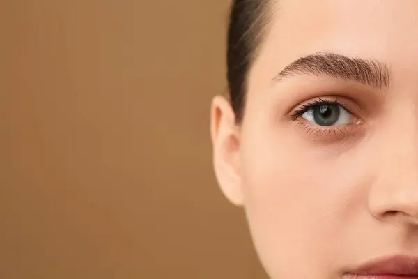 茶色の背景に完璧な眉毛を持つ若い女性 クローズアップ テキスト用スペース — ストック写真