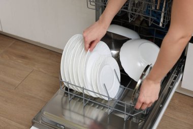 Bulaşık makinesini tabaklarla dolduran kadın, yakın plan.