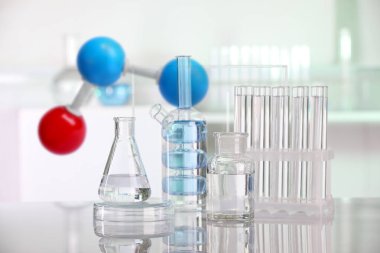 Laboratuvarda farklı cam eşyalar ve molekül modelleri var.