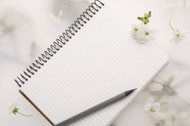 Konuk listesi. Not defteri, kalem ve güzel kiraz ağacı çiçekleri bahar çiçekli arka planda, düz yatıyordu.