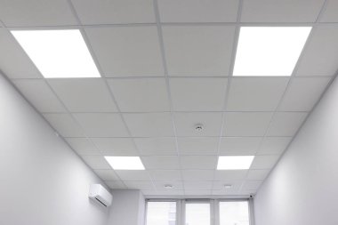 PVC fayanslı beyaz tavan ve kapalı alanda ışıklandırma, düşük açı görünümü
