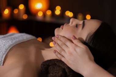 Spa terapisi. Salondaki masaj sırasında masada uzanan güzel genç bir kadın.