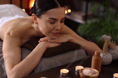 Spa terapisi. Salondaki masaj masasında uzanmış güzel genç bir kadın.