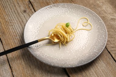 Tahta masada çatal ve spagetti ile yapılmış bir kalp.