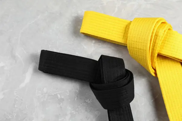 Zwarte Gele Karate Riemen Grijze Marmeren Achtergrond Plat Gelegd — Stockfoto