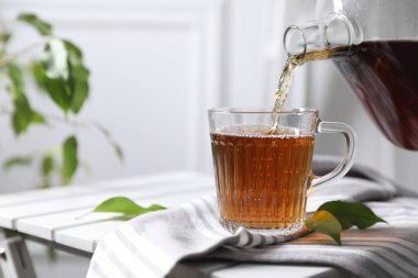 Sıcak çayı masaya dök, yakından.