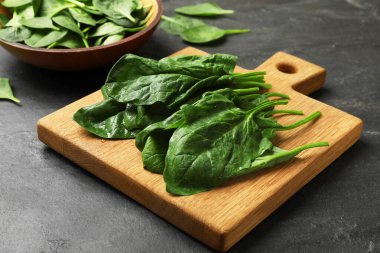 Üzerinde ıslak ıspanak yaprakları olan tahta koyu desenli masa, yakın plan.