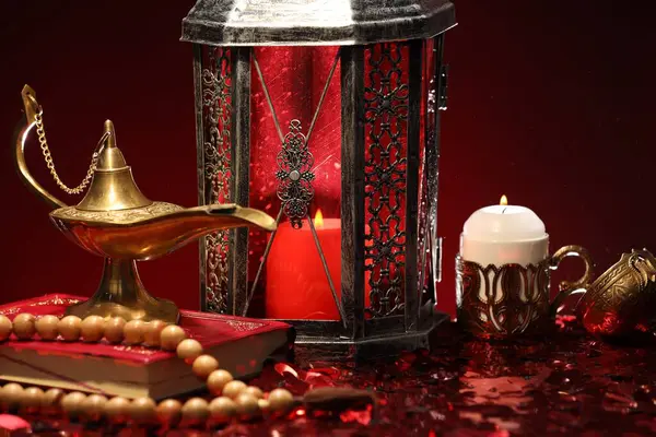 Arap feneri, Kur 'an, Misbaha, yanan mum ve parlak kırmızı masada Aladdin sihirli lamba.