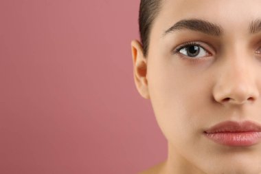 Pembe arka planda mükemmel kaşları olan genç bir kadın, yakın plan. Metin için boşluk
