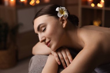 Spa terapisi. Salondaki masaj masasında uzanmış güzel genç bir kadın.