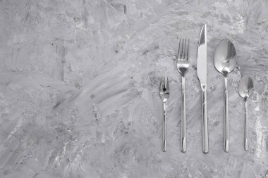 Gri masadaki güzel çatal bıçak seti, düz yatıyordu. Metin için boşluk
