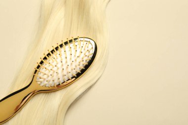 Sarı saç telli, bej arka planda şık fırça, üst manzara. Metin için boşluk