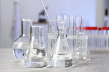 Laboratuvar analizi. Açık gri masada farklı camlar var.