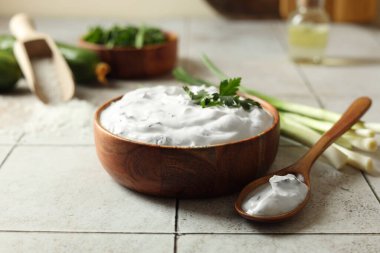 Lezzetli yoğurt, yeşil soğan ve kaşık açık fayanslı masa, yakın çekim.