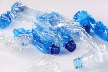 Kırışmış tek kullanımlık plastik şişeler beyaz arka planda