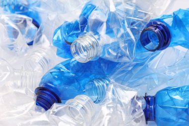 Arka plan olarak buruşmuş tek kullanımlık plastik şişeler, yakın plan.