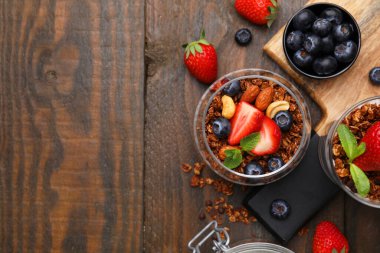 Lezzetli granola, böğürtlen ve fındıklar ahşap masada, düz yatıyordu. Metin için boşluk