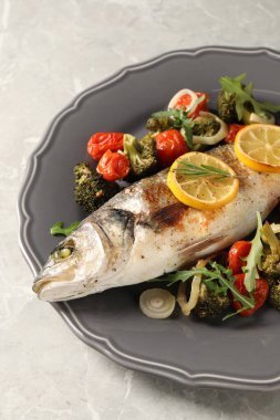 Pişmiş balık ve sebze, biberiye ve limon.