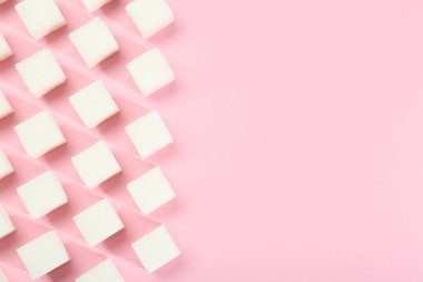 Pembe arka planda beyaz şeker küpleri, üst manzara. Metin için boşluk