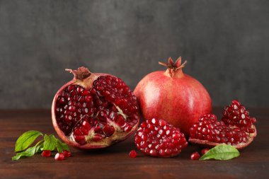 Taze nar ve yeşil yapraklar ahşap masada.