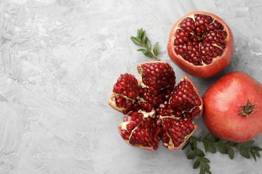 Taze nar ve yeşil yapraklar gri desenli masada, düz yerde. Metin için boşluk