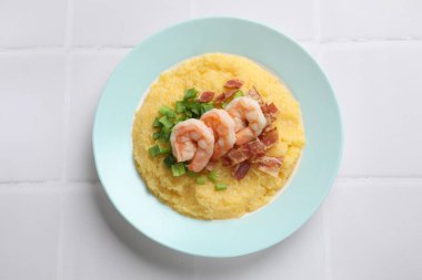 Taze karides, domuz pastırması, yulaf ve yeşil soğan tabağı beyaz fayanslı masa, üst manzara