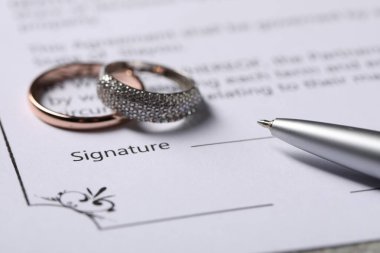 Evlilik sözleşmesi, kalem ve alyanslar, yakın plan.